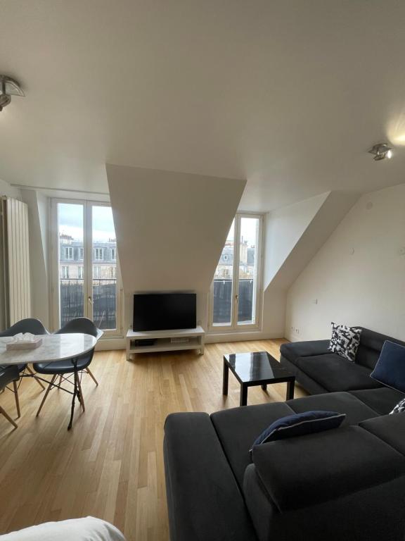 un salon avec un canapé et une télévision dans l'établissement Paris 5e arr Place Saint Michel, à Paris