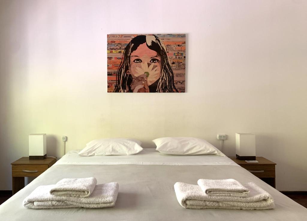 a bed with two towels and a painting on the wall at Habitación En España 1512 in Mendoza