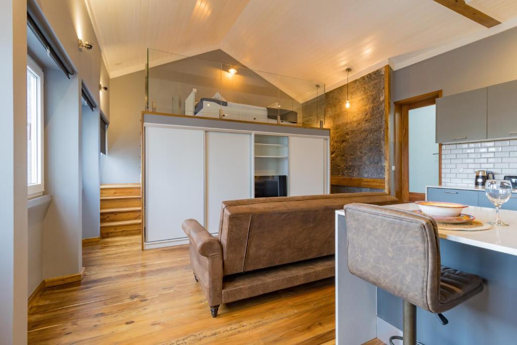 a kitchen and dining room with a couch and a table at Canto do Atlântico Loft (City Centre) in Ponta Delgada