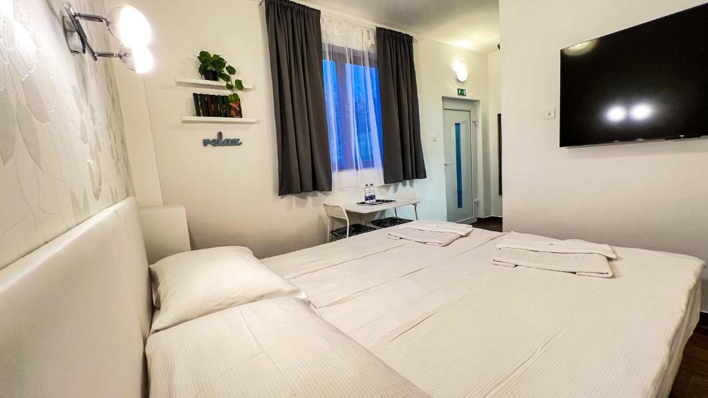 a bedroom with a white bed with two towels on it at Rooms Koblar in Portorož