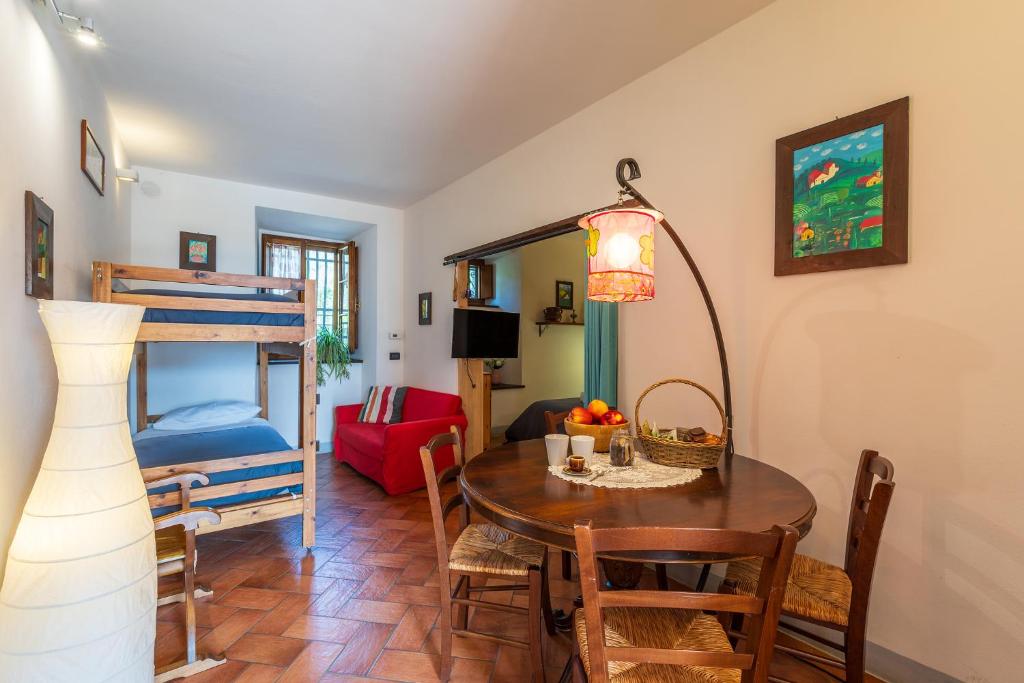 salon ze stołem i łóżkiem piętrowym w obiekcie Agriturismo Fattoria Podere Peciano w mieście Cortona