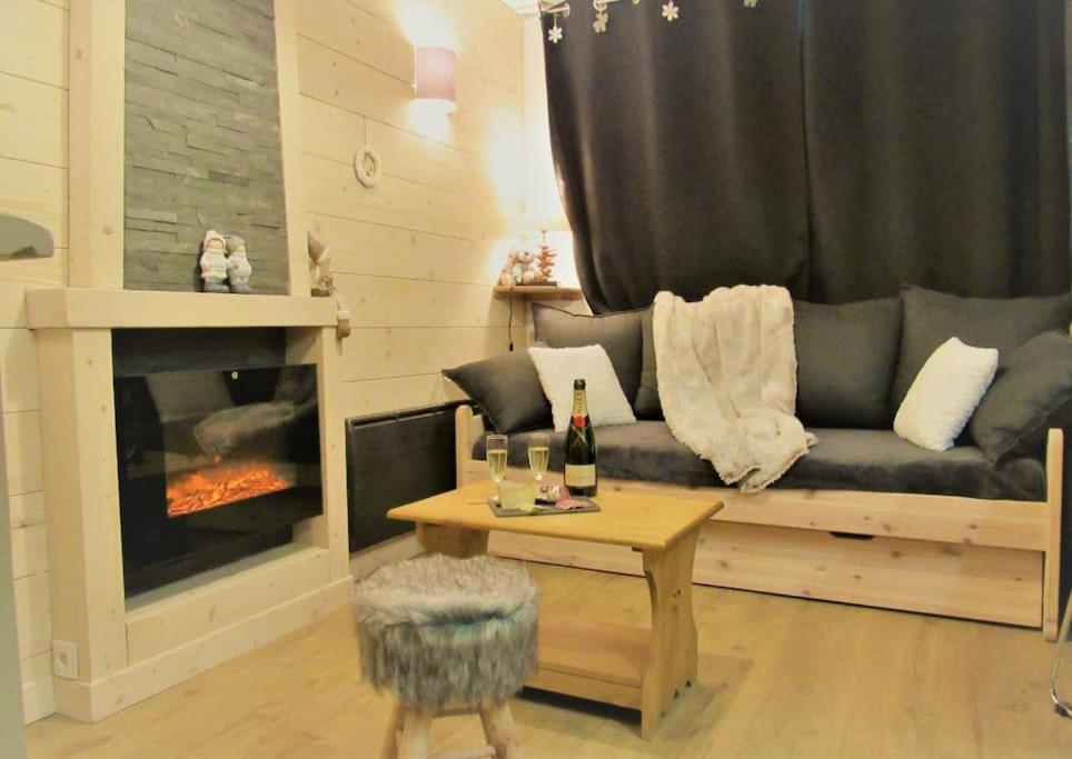un salon avec un canapé et une cheminée dans l'établissement Val thorens appartement 2 ch avec belle vue sud, à Val Thorens
