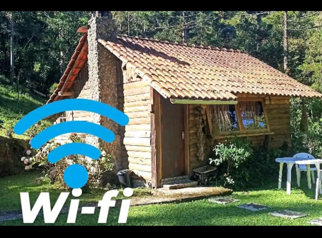 um pequeno chalé de madeira com um sinal de wi-fi em frente em Chalé do Coiote em Maromba em Visconde de Mauá