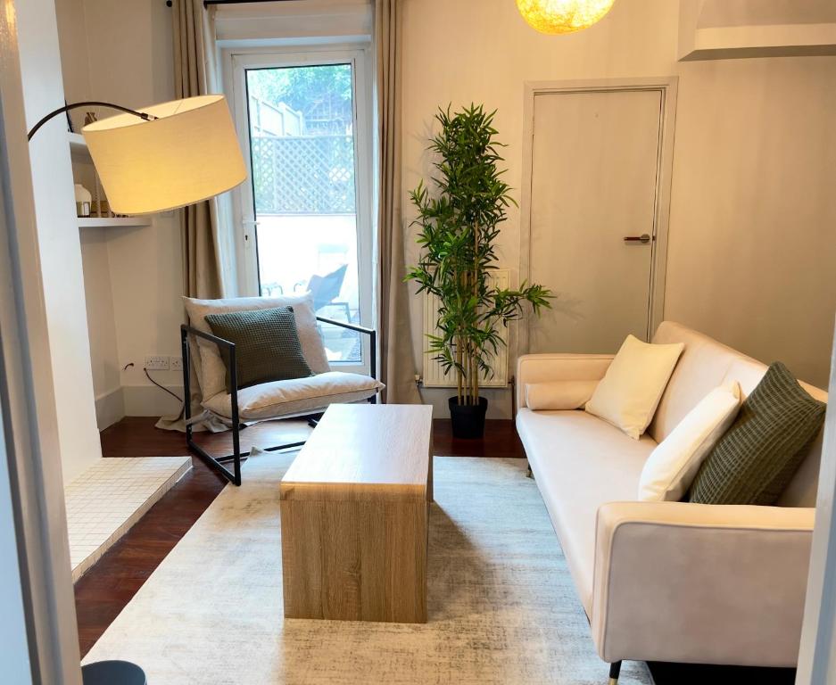 a living room with a couch and a table at London Townhouse 1-Bed Apartment with Garden in Tufnell Park near Emirates Stadium and 10 mins to Kings Cross in London