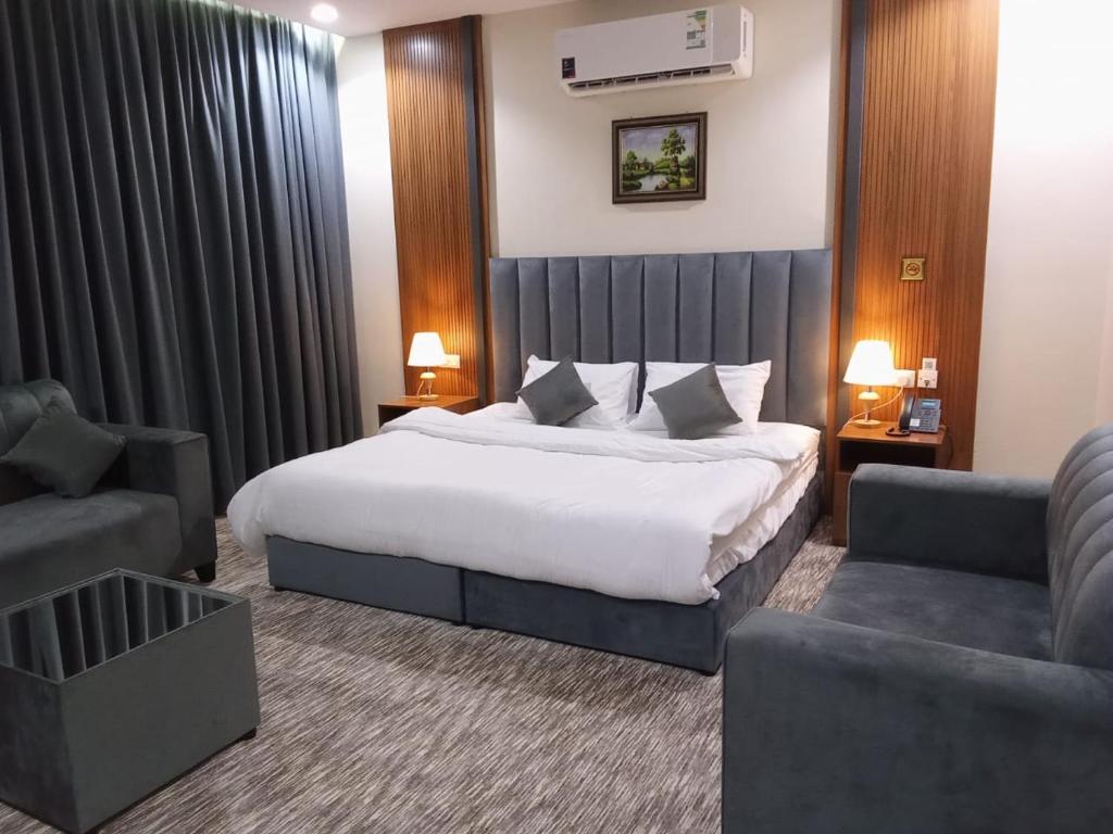 une chambre d'hôtel avec un lit, une chaise et un canapé dans l'établissement فندق انسام طيبة للضيافة, à Médine
