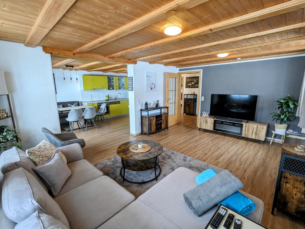 a living room with a couch and a tv at Ferienwohnung Alpenblick Dorner in Oberreute