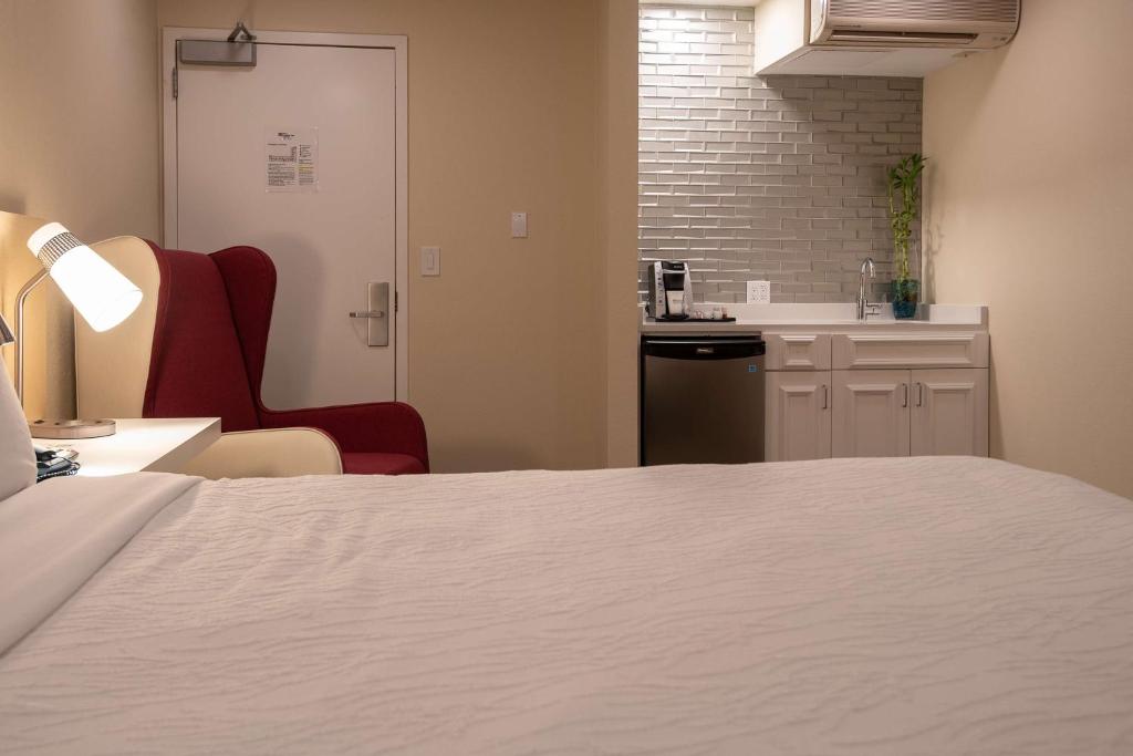 Zimmer mit einem Bett und einem Stuhl sowie einer Küche in der Unterkunft Hilton Garden Inn Calabasas in Calabasas