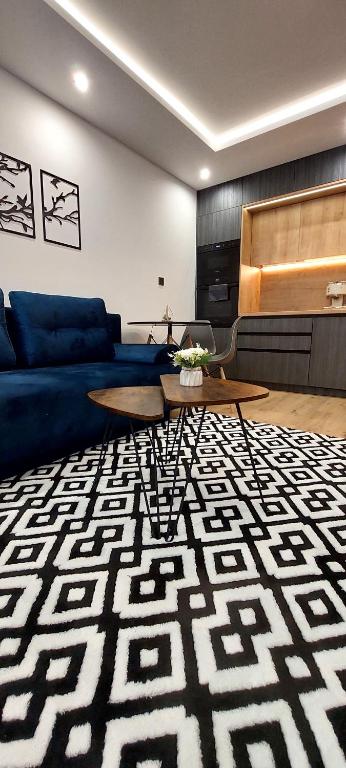 uma sala de estar com um sofá azul e um tapete em Apartmán Porte em Košice