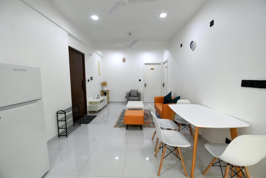 una camera con divano, tavolo e sedie di Seaview Apartment by Lin Residences a Città di Malé