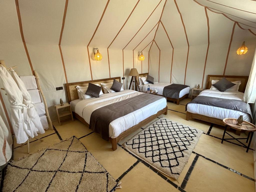 a bedroom with two beds in a room at Camp Sakura Desert Dream in Merzouga