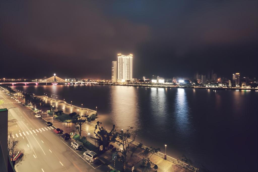 a view of a city at night with the water at Hoang Linh Riverside Hotel Danang in Da Nang