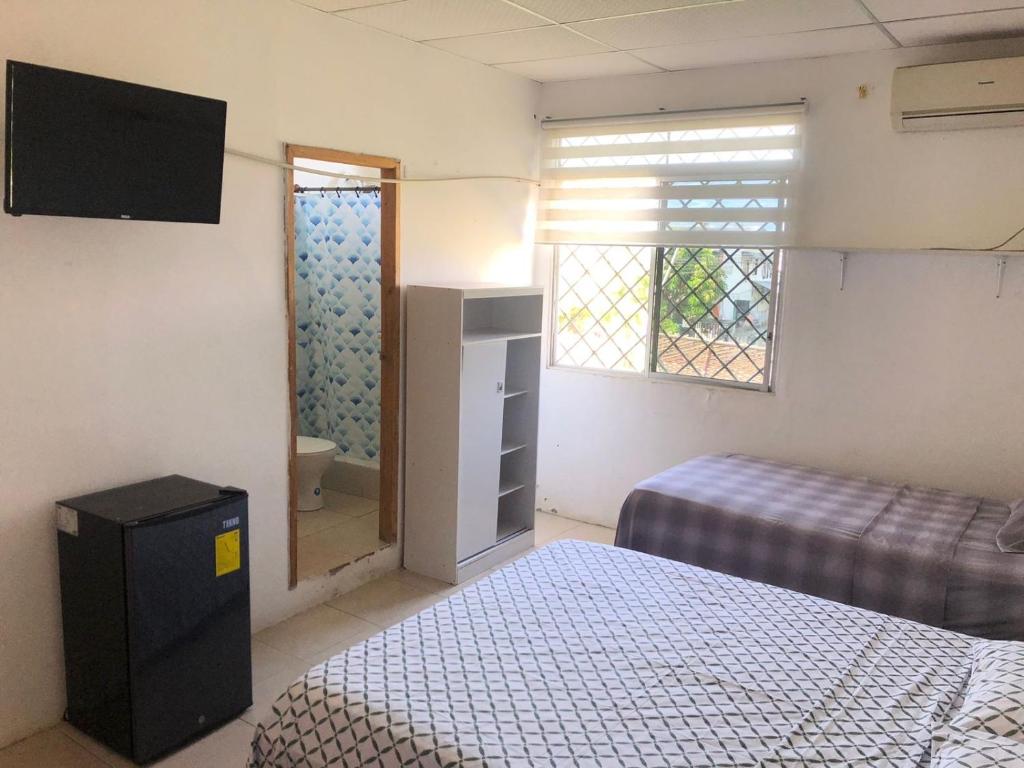a small room with two beds and a window at Pargo, habitación privada de Flor de Lis Beach House in Playas