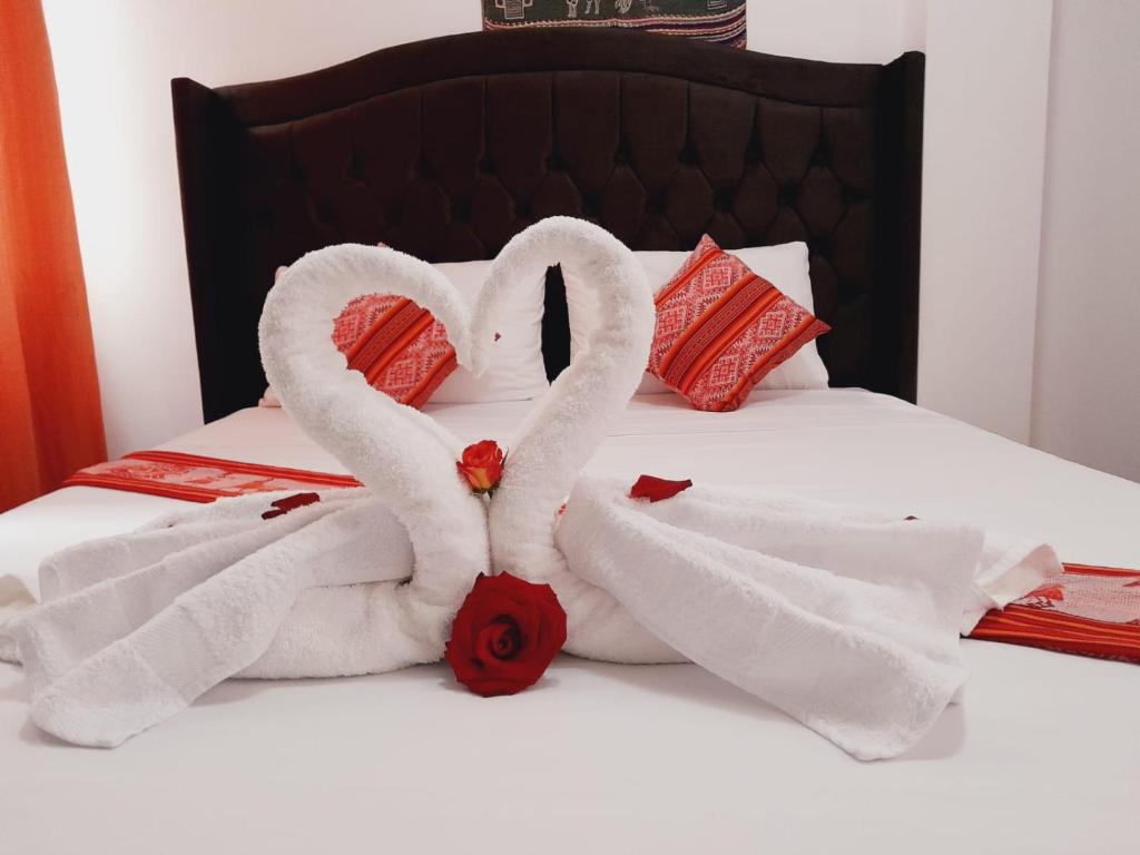 two swans made out of towels on a bed at Fenix Hotel Machupicchu in Machu Picchu