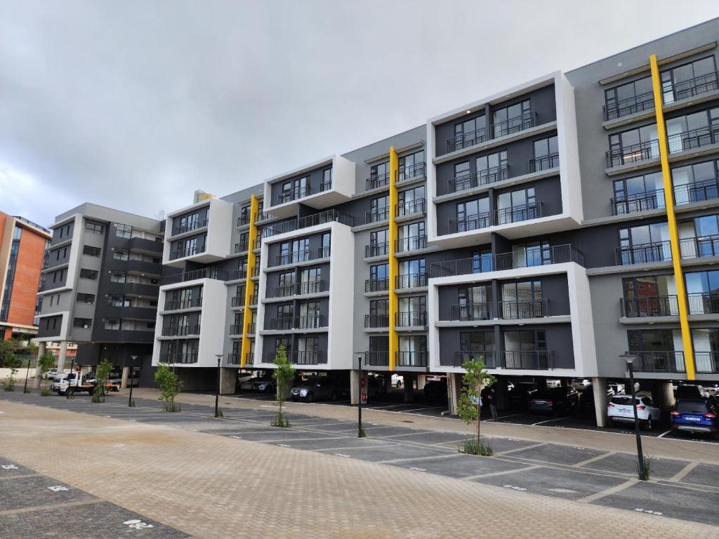 ein Apartmenthaus mit gelben Säulen auf einer Straße in der Unterkunft Luxurious Millennium, uMhlanga Durban in Durban