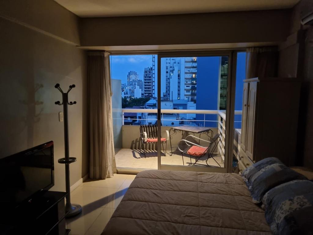 a bedroom with a bed and a balcony with a view at Palermo Soho in Buenos Aires