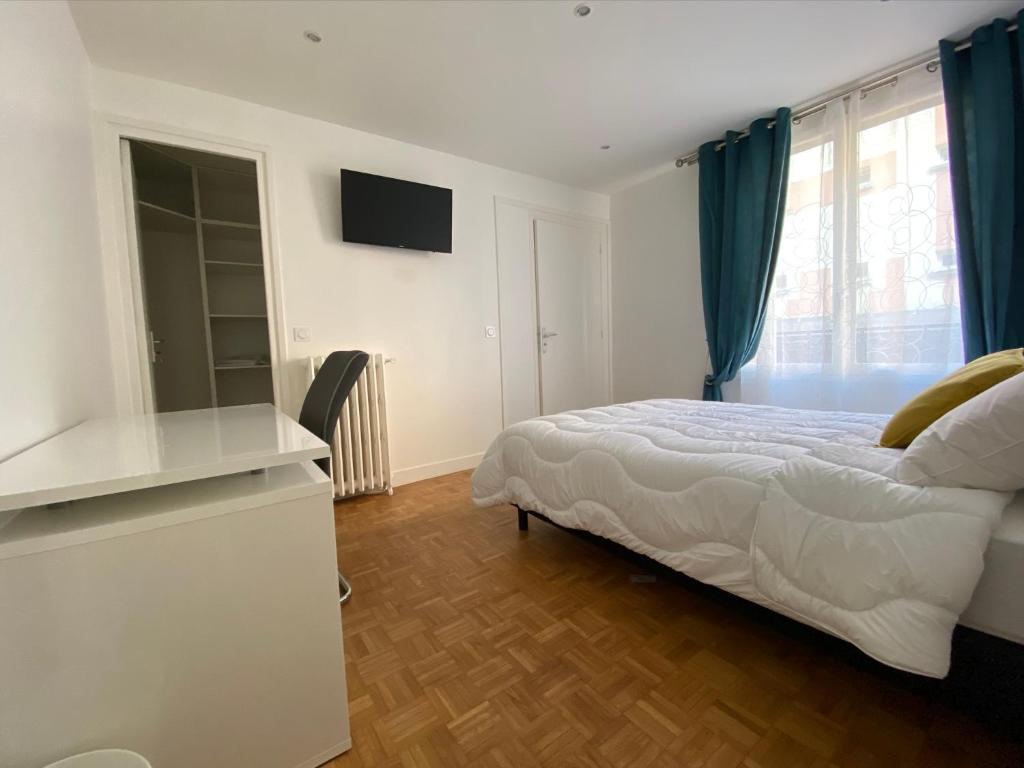 een witte slaapkamer met een bed en een televisie bij Appartement Amaya 1 - 100 m2 Paris 2024 in Pontoise