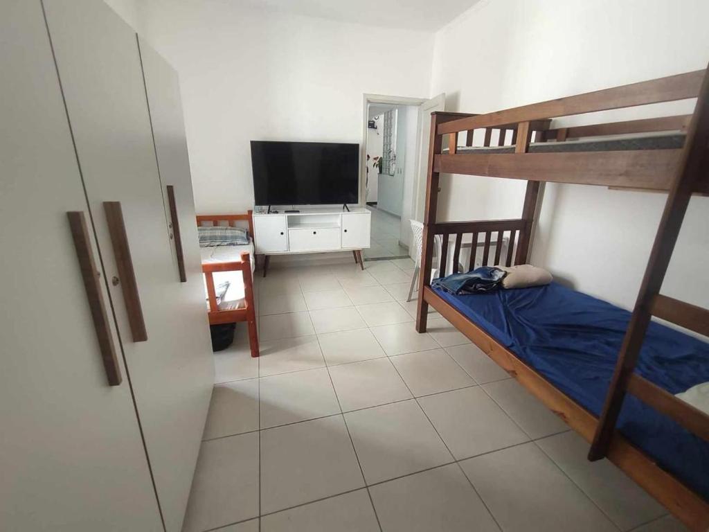 a bedroom with a bunk bed and a television at Residência RCA13 in Santos