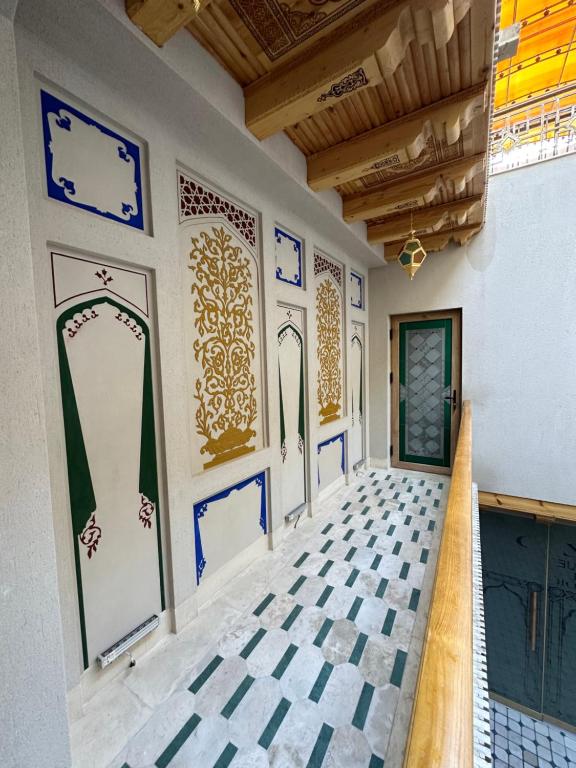 um quarto com pisos em azulejo azul e branco e uma porta em Rizo Boutique em Bukhara