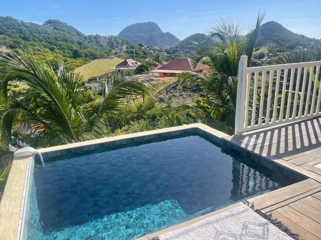 a swimming pool with a view of the mountains at Le Paradis créole in Terre-de-Haut