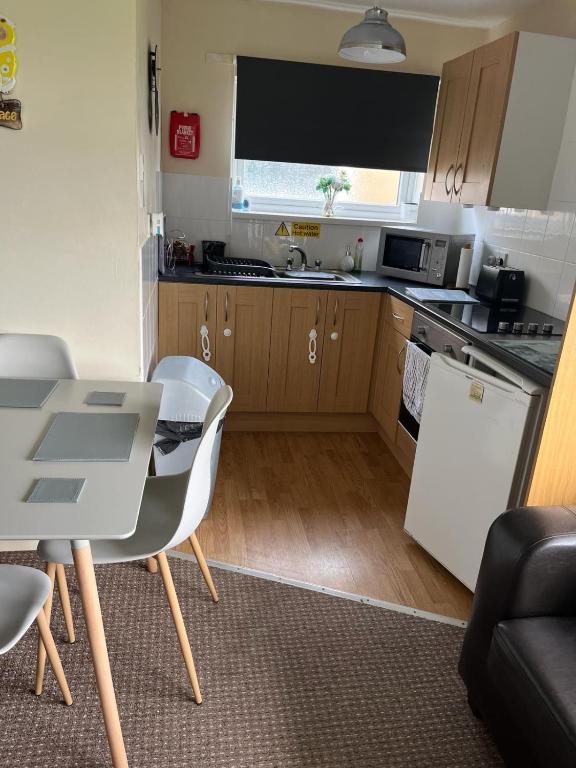 a small kitchen with a table and chairs and a table and a counter at Mells Shells in Hemsby