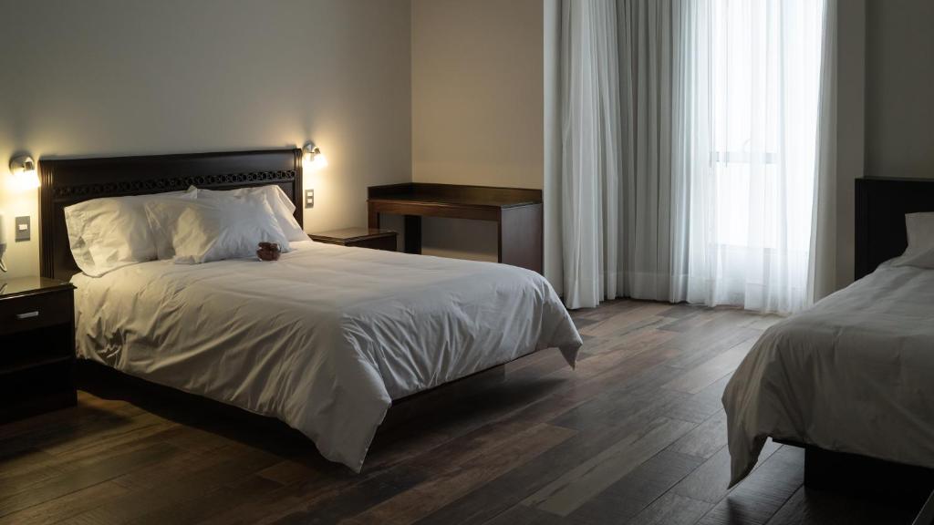 una camera da letto con un grande letto con lenzuola bianche di LIMA HOST a Lima