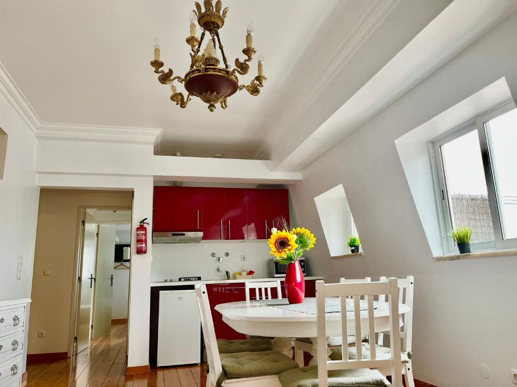 uma cozinha com mesa e cadeiras e um candelabro em 2 Bedroom, 2 Bathroom With Terrasse - Palma Residence em Lisboa