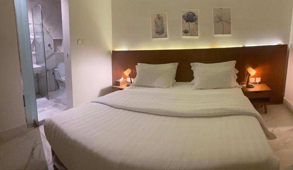 um quarto com uma grande cama branca e 2 candeeiros em شقق درة بارك الشقيق em Ash Shuqayq