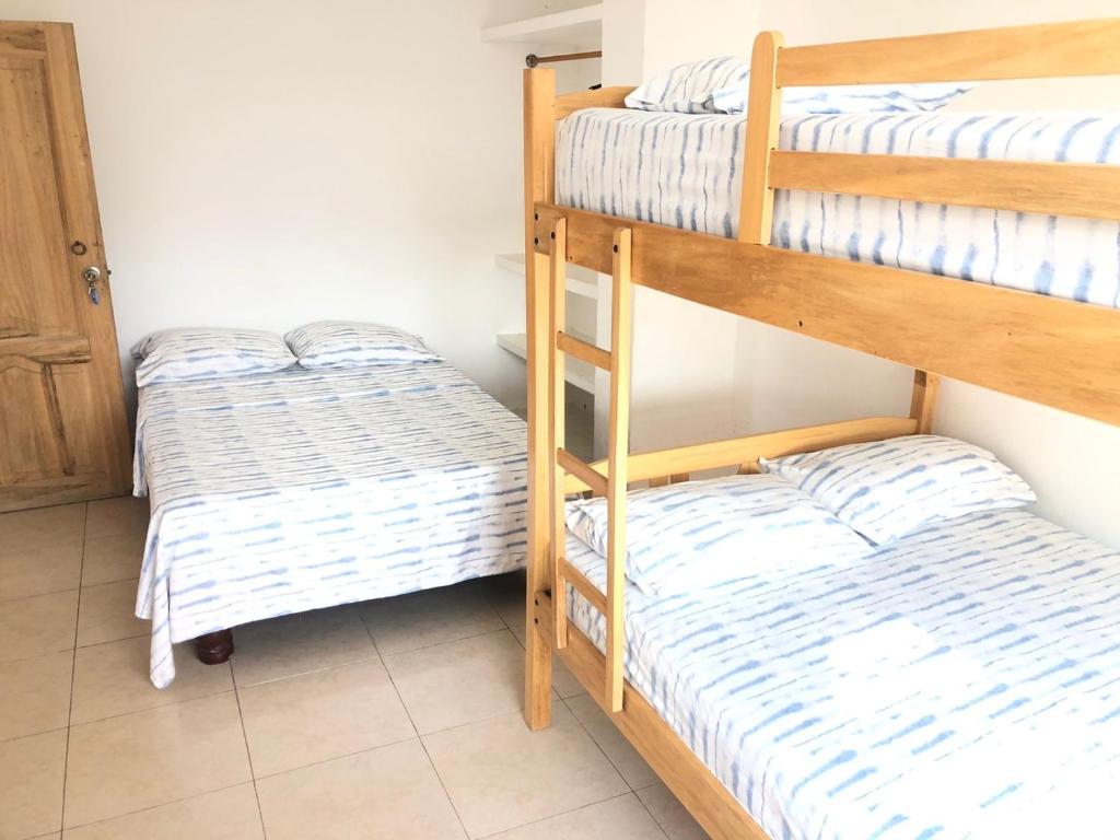 two bunk beds in a small room with at Pangora, habitación privada de Flor de Lis Beach House in Playas