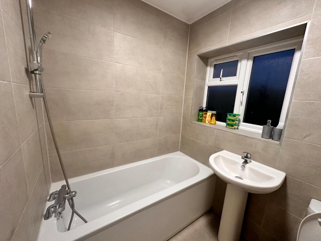 a bathroom with a bath tub and a sink at Kriss house in Bristol