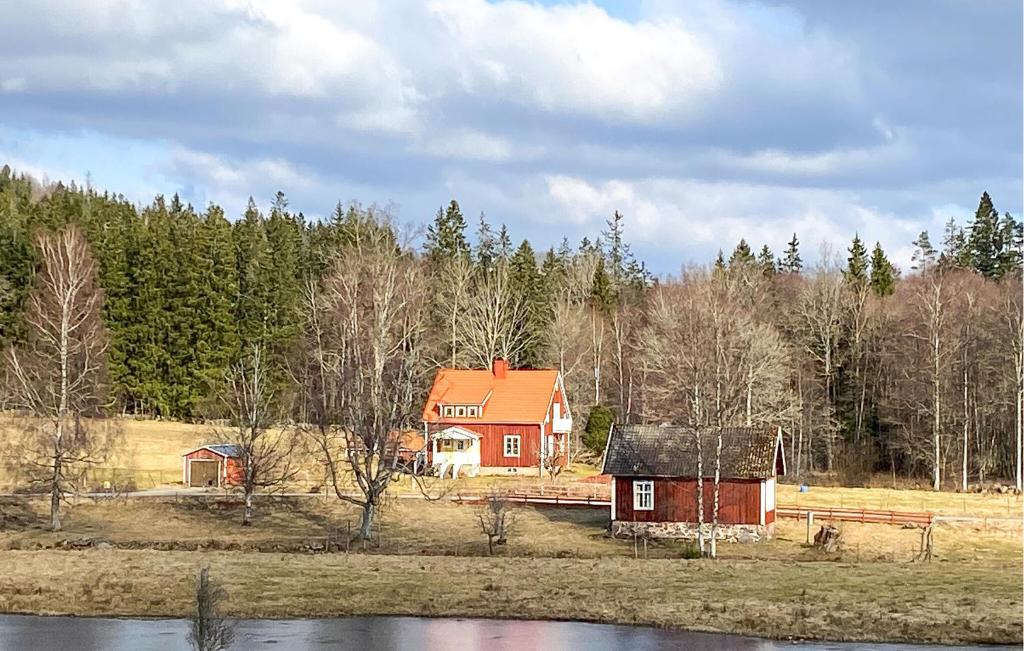 a red house with a red roof next to a lake at 4 Bedroom Beautiful Home In Rrvik in Rörvik