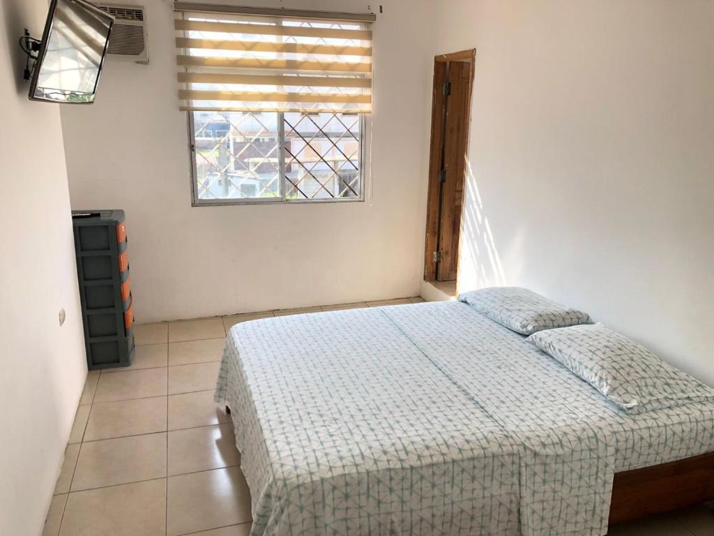 a bedroom with a bed and a window at Estela, habitación privada de Flor de Lis Beach House in Playas