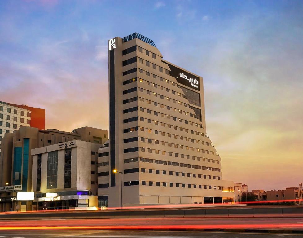 a tall building with a sign on top of it at Dar Rayhaan by Rotana Al Khobar in Al Khobar