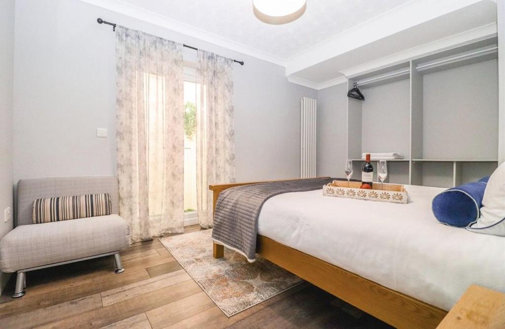 a bedroom with a large bed and a chair at Large villa sleeping 8 under 5 minute walk to beach in Caister-on-Sea