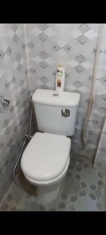 een wit toilet in een badkamer met een muur bij Apmb in Dakar