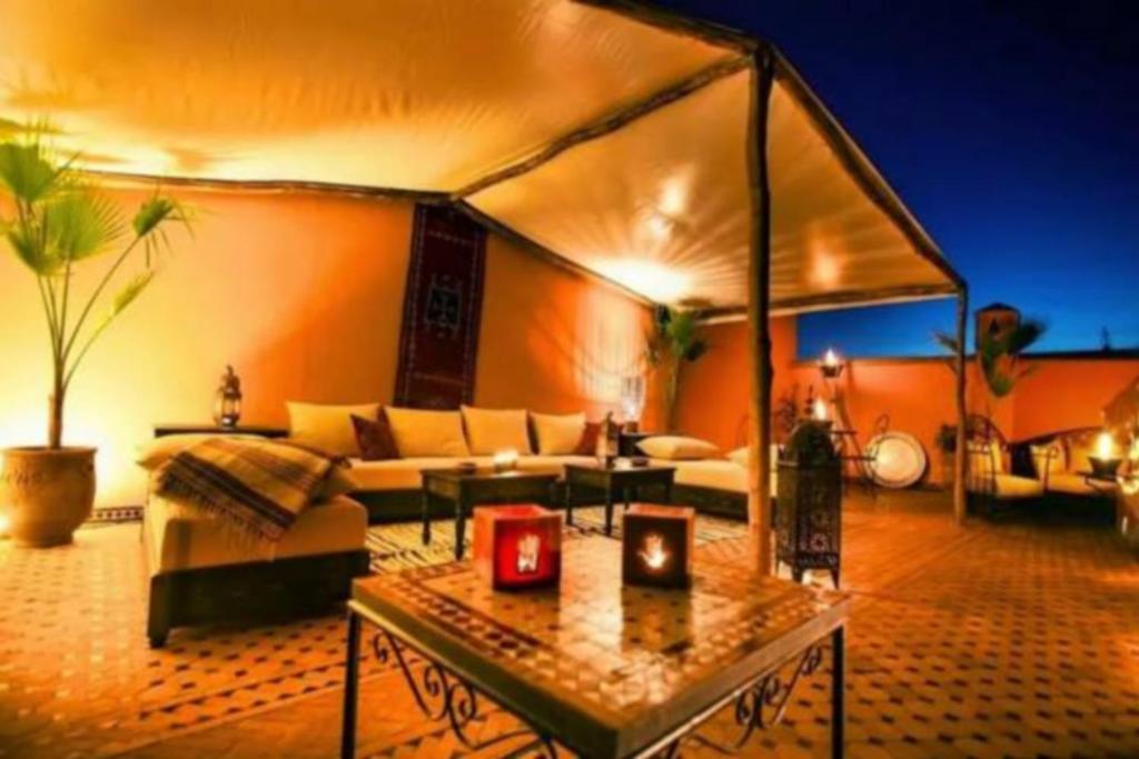 Riad Moonlight & Spa في مراكش: غرفة معيشة مع أريكة وطاولة
