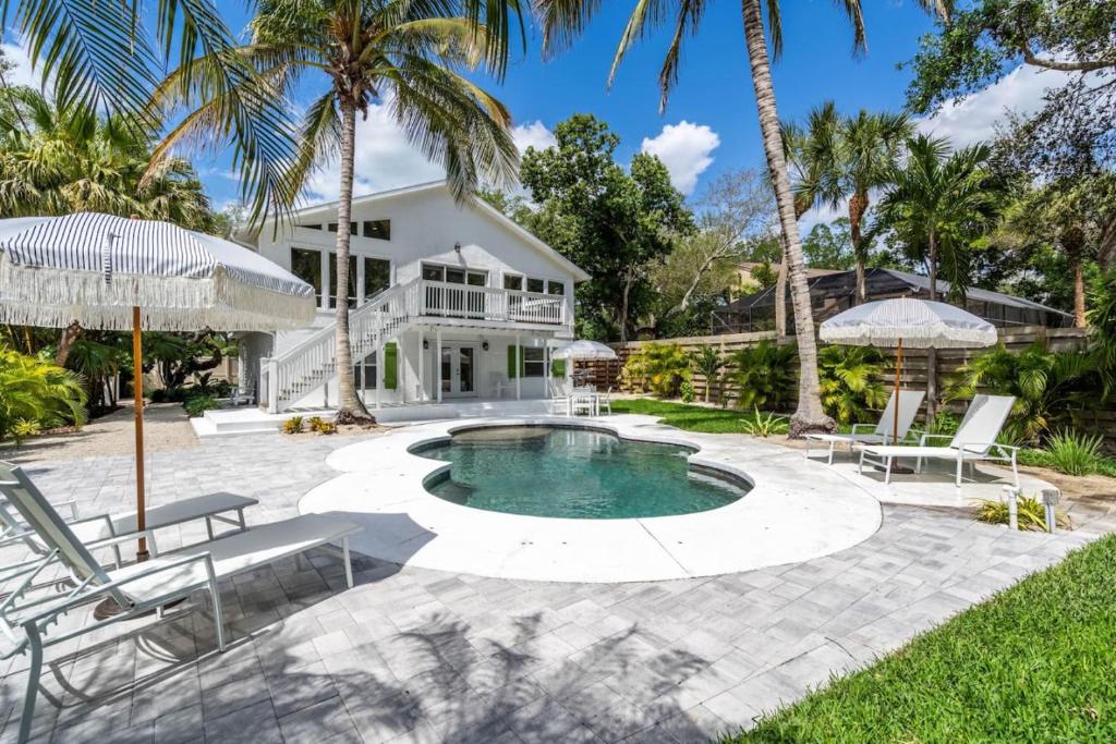 a house with a swimming pool and palm trees at Luxury getaway steps from beach sleeps 10 in Siesta Key