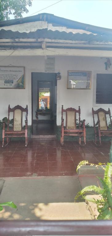 dos bancos sentados frente a un edificio en Ortiz Hospedaje Ometepe, en Altagracia