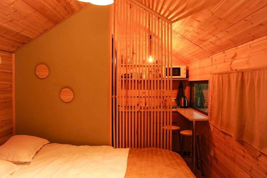 a bedroom with a bed and a desk in a room at Jvarisa Glamping in Ambrolauri