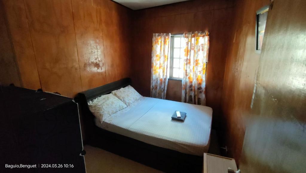 a small bed in a room with a window at Kochimoto Guesthouse in Baguio