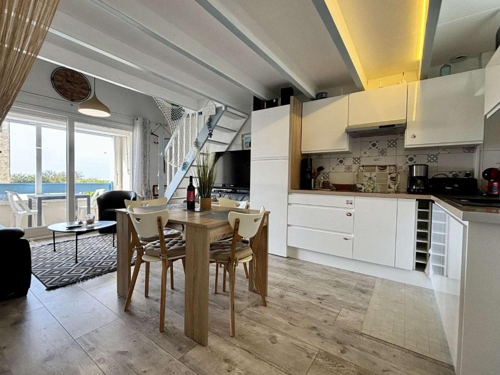 uma cozinha e sala de jantar com mesa e cadeiras em Appartement Saint-Pierre-d'Oléron, 2 pièces, 4 personnes - FR-1-246A-294 em Saint-Pierre-dʼOléron