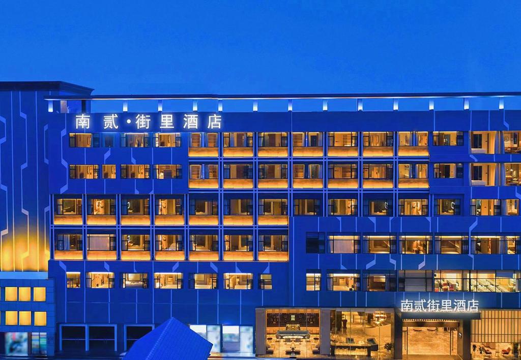 een blauw gebouw met lichten aan bij Nan'er Jieli Hotel - Chengdu Tianfu International Airport Branch in Jianyang
