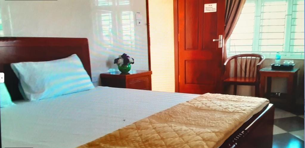um quarto com uma cama, uma mesa e uma cadeira em Nhà nghỉ Thanh Bình em Ngô Xa