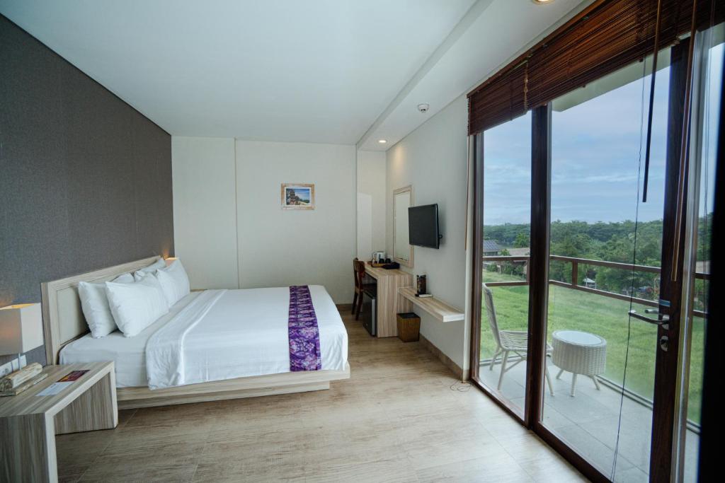 a hotel room with a bed and a balcony at The Evitel Resort Ubud in Ubud