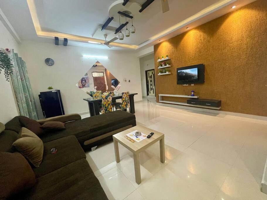 a living room with a couch and a table at Beautiful 2bhk near Begumpet in Hyderabad