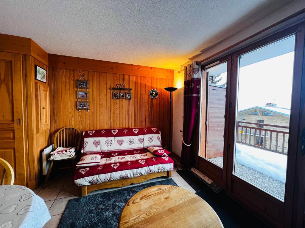 ein Wohnzimmer mit einem Sofa und einem großen Fenster in der Unterkunft Appartement Les Saisies, 2 pièces, 6 personnes - FR-1-293-399 in Hauteluce