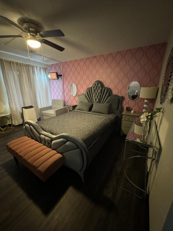- une chambre avec un grand lit et une chaise dans l'établissement The Village Inn Hotel, à Milwaukee