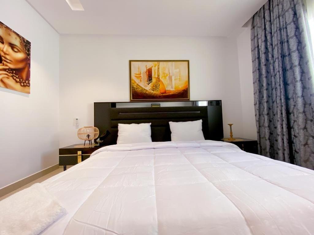1 cama blanca grande en un dormitorio con ventana en Kalilu Holiday apartment, en Brusubi