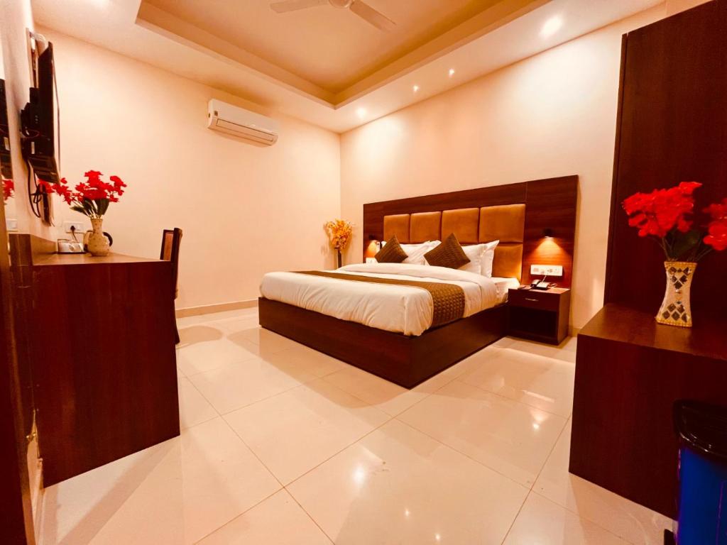 a bedroom with a bed and flowers in a room at Olive Tree Resort, Haridwar in Haridwār