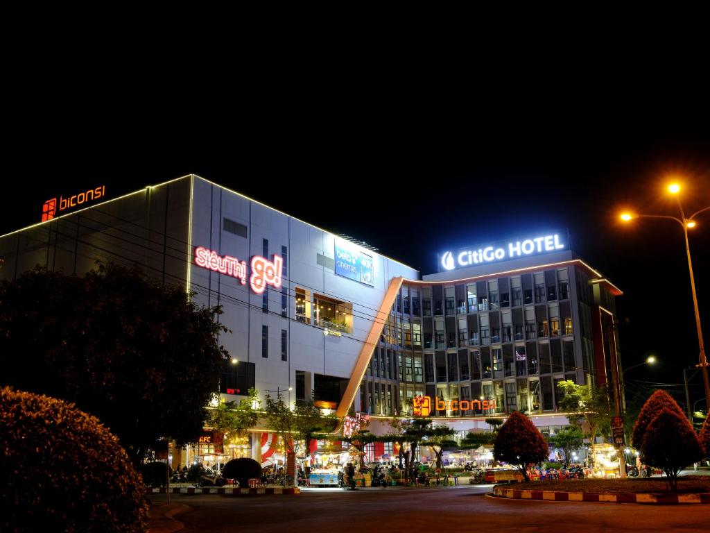 un grand bâtiment avec un panneau la nuit dans l'établissement CitiGo HOTEL - 越南平阳新渊欢阁酒店, 