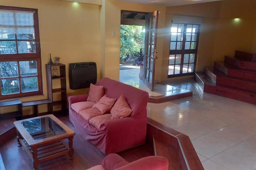 a living room with a red couch and a coffee table at comodidad y tranquilidad in Jesús María